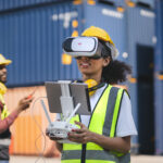 Engineer uses VR headset to remote control drone with blue containers background