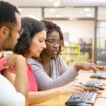 Three people learning in front of a computer screen.