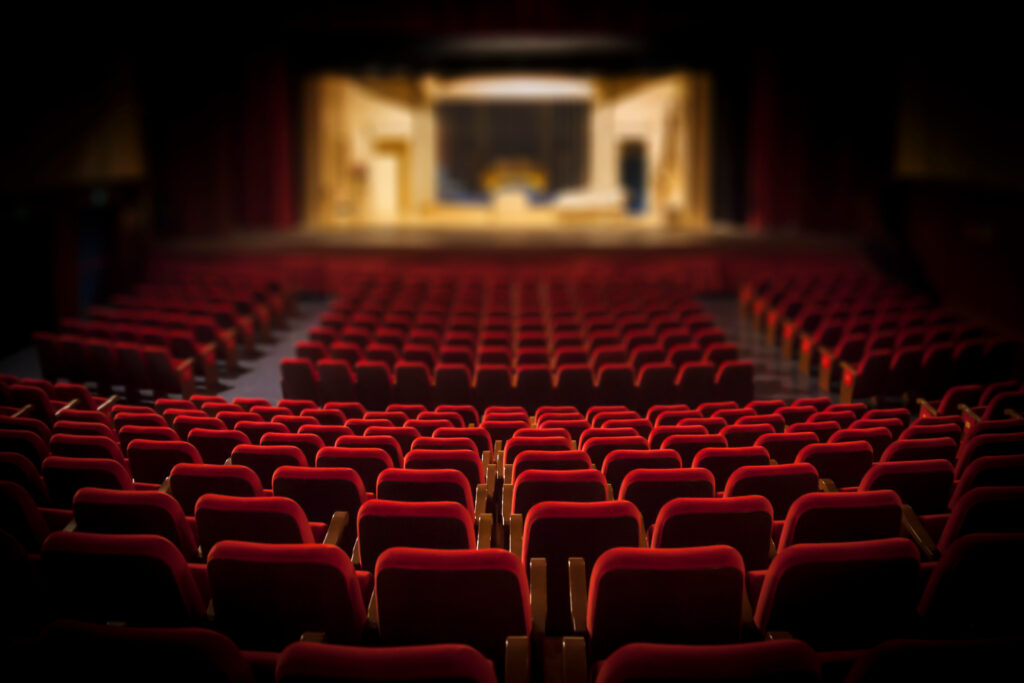Empty red chairs in a large auditorium