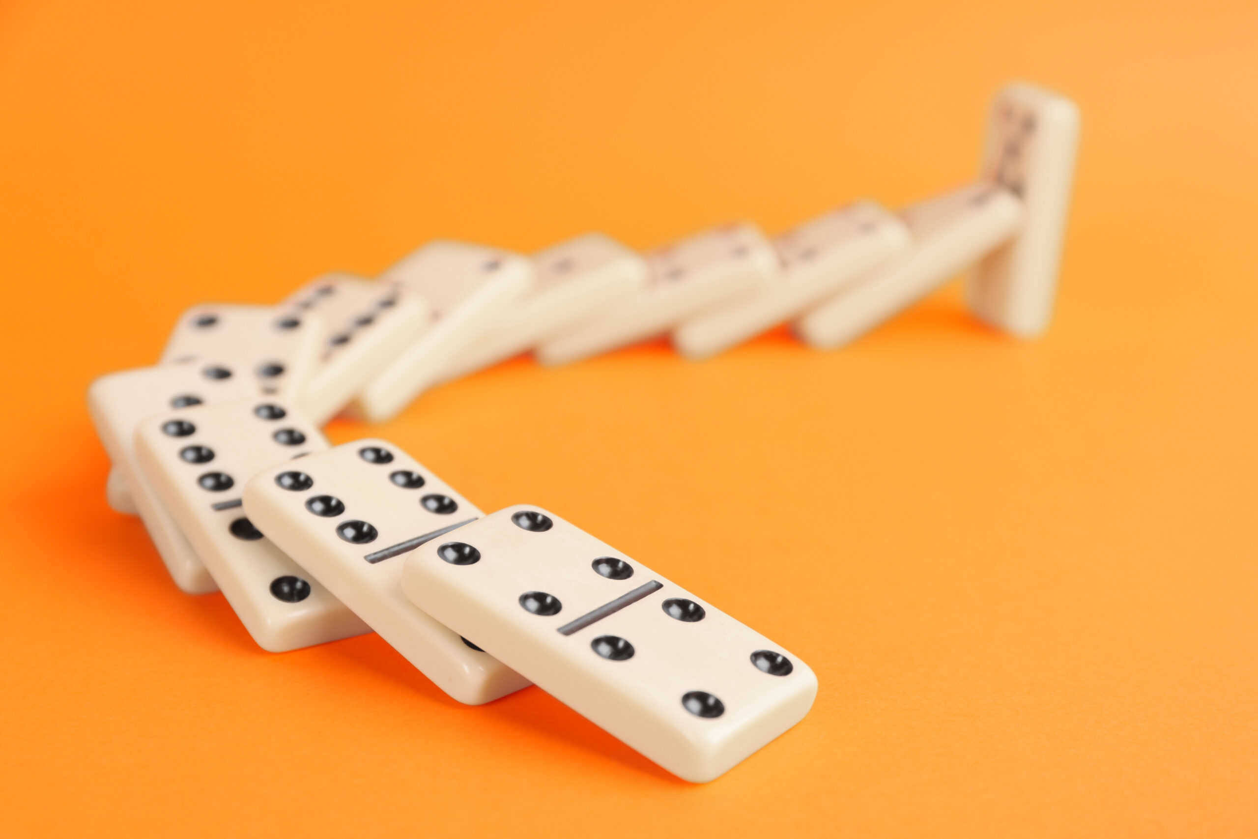Downloaded White domino tiles falling on orange background