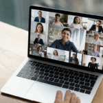 Closeup photo of laptop screen showing colleagues on a Zoom meeting.